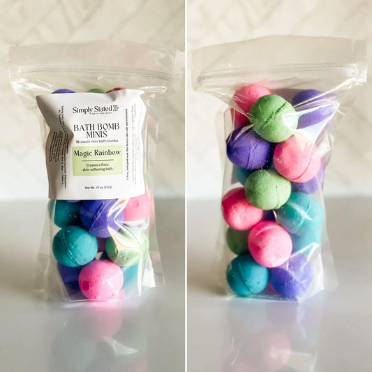 Packaged bath bomb minis with a 'Simply Stated' label on a white background scented in Magic Rainbow