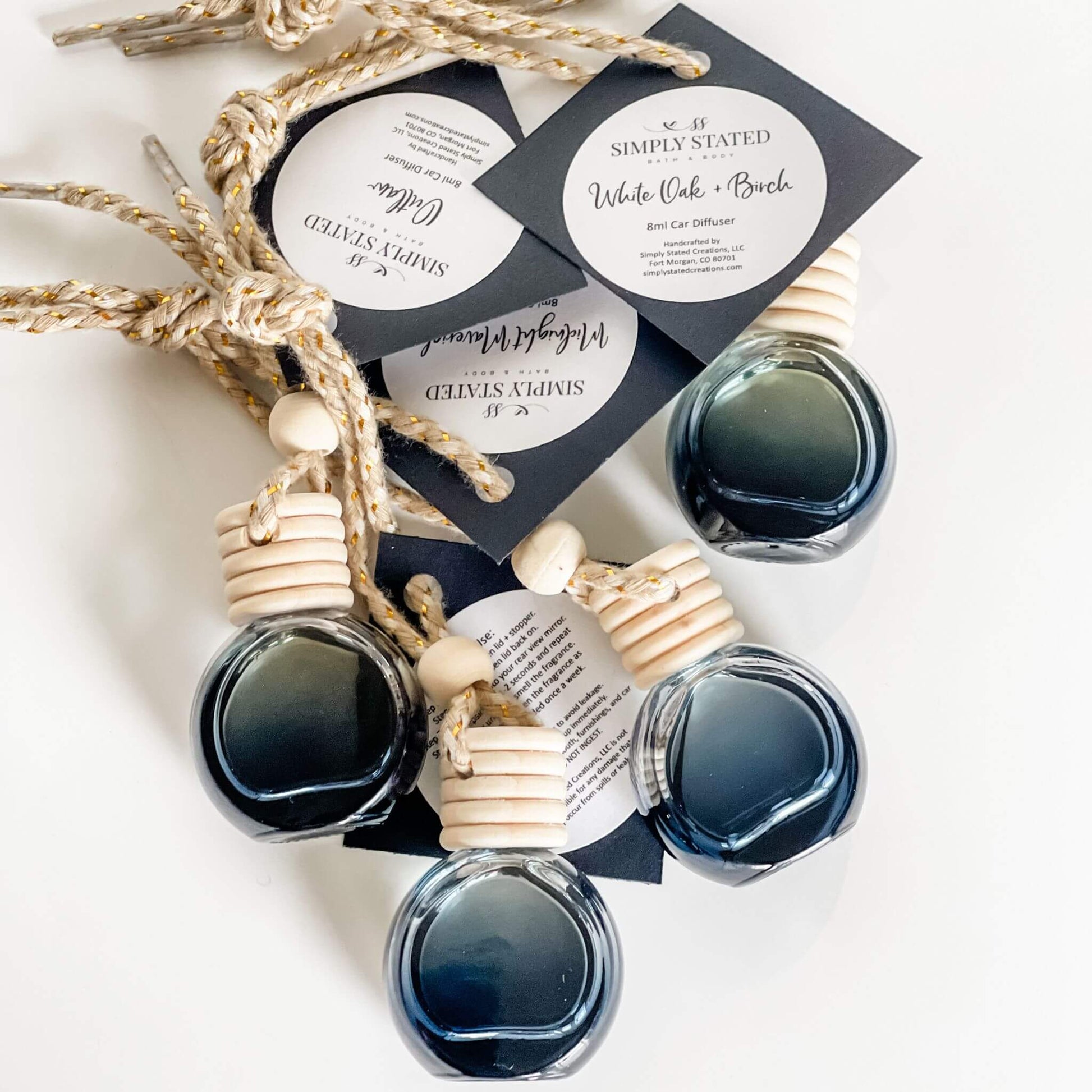 Flat lay of Men’s Car Diffusers in black glass bottles with updated branding