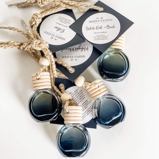 Flat lay of Men’s Car Diffusers in black glass bottles with updated branding
