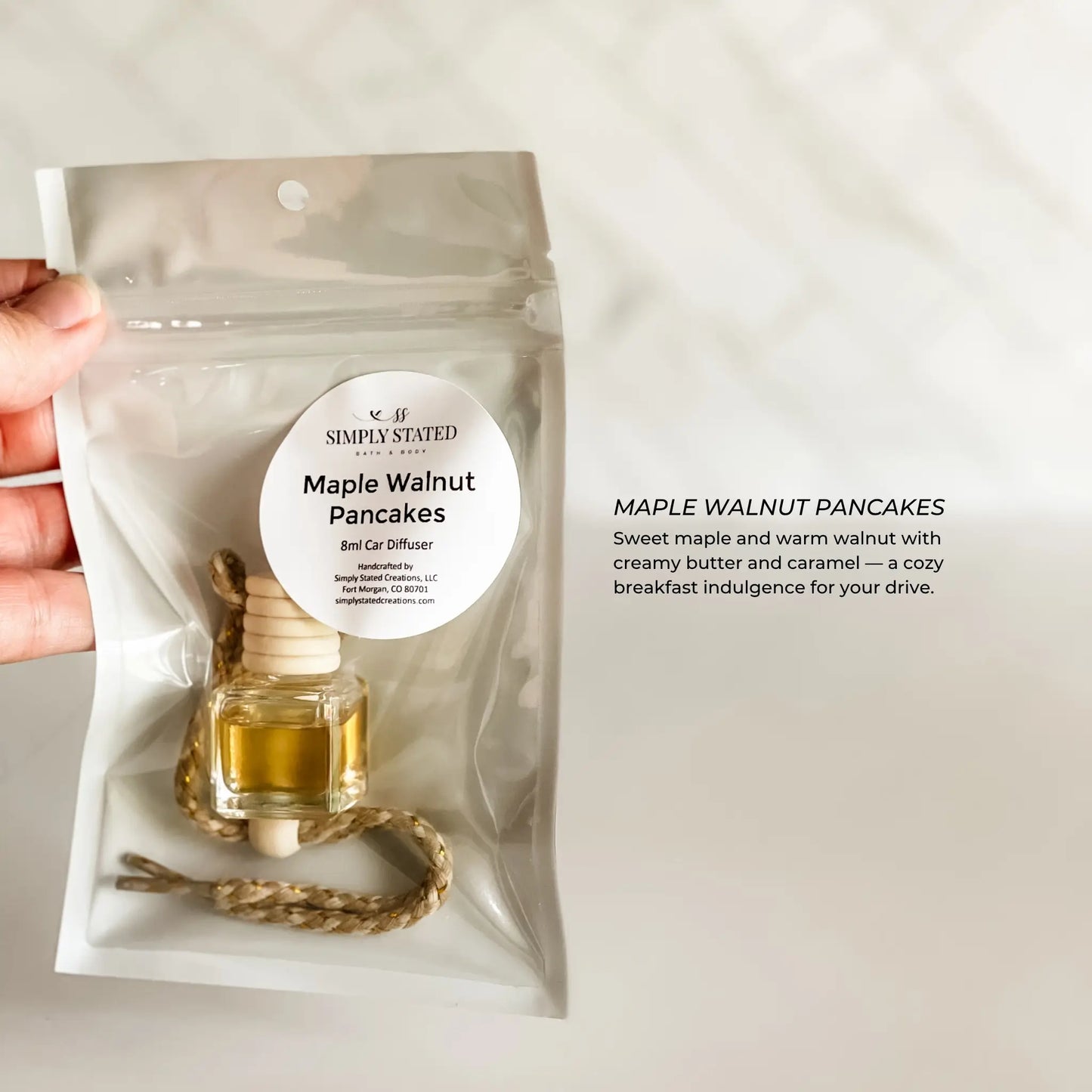 Bag of 'Maple Walnut Pancakes' scented diffuser with a hand holding it on a light background