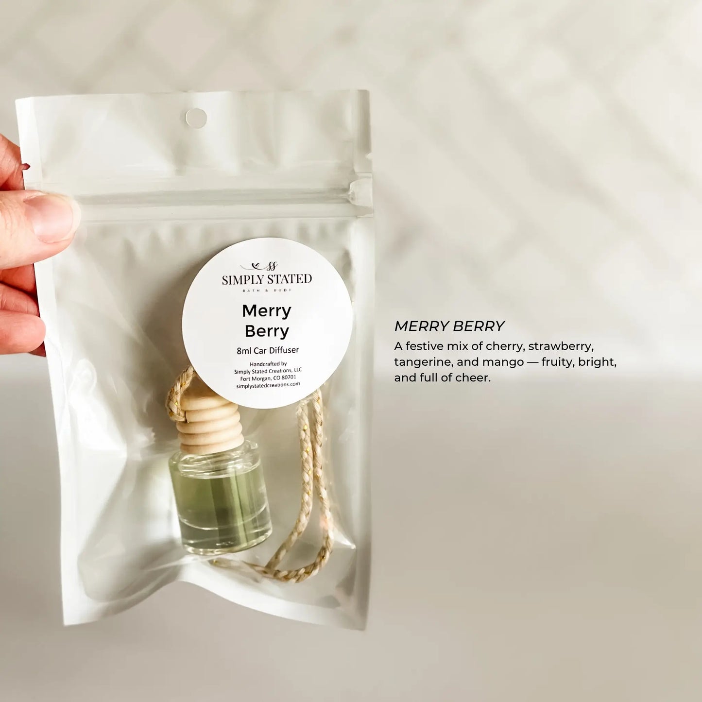 Merry Berry diffuser packaging held by a hand on a light gray background